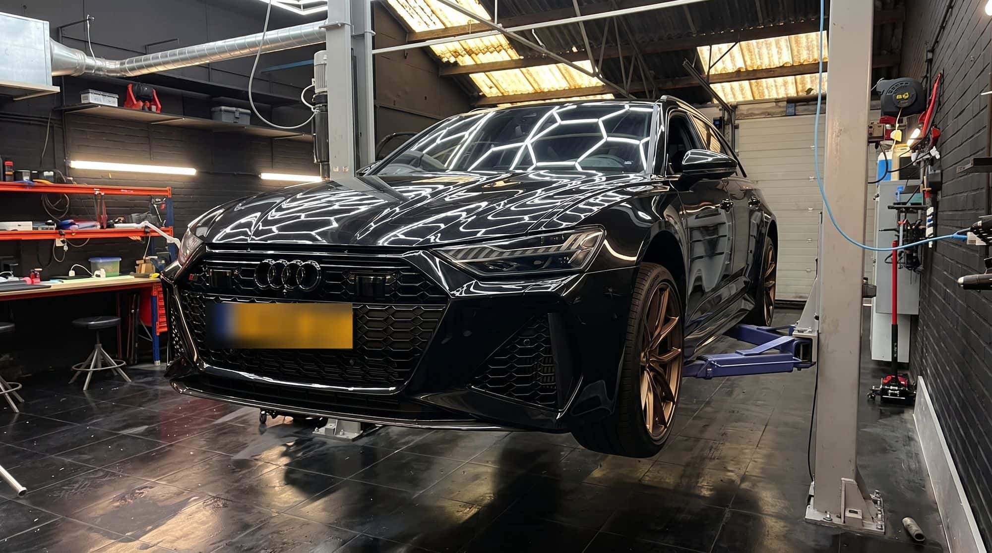 Zwarte Audi RS 6 Avant op de brug in de werkplaats