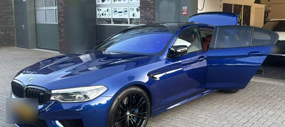 Blauwe BMW M5 met geopende portieren