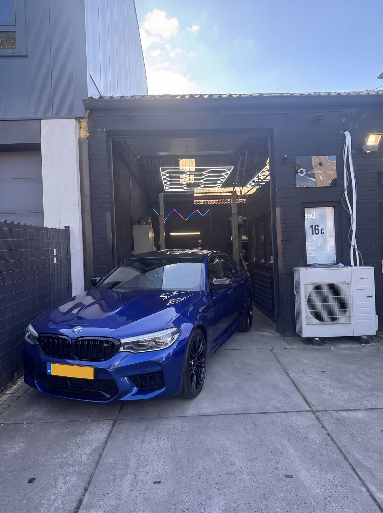 Voorgevel van de werkplaats aan de Industrieweg 16c in Soest, met een blauwe BMW voor de roldeur