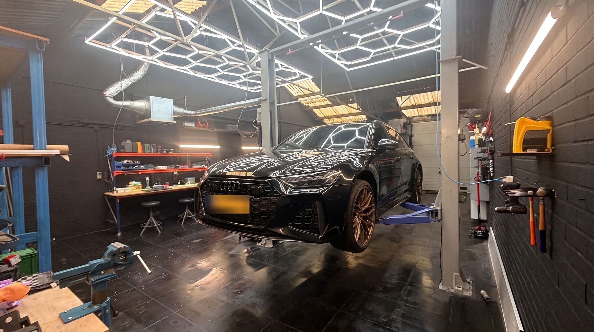 Zwarte stationwagon op de brug in de werkplaats