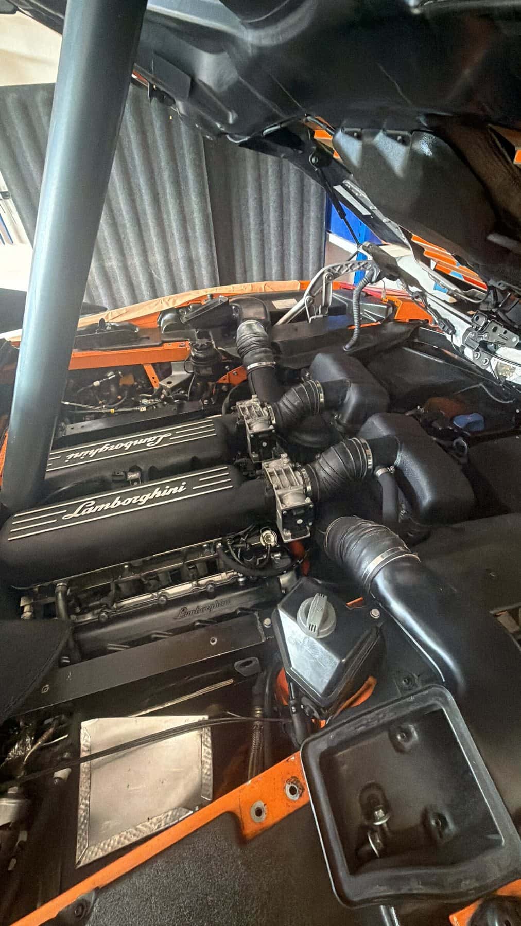 Middenmotor van een supercar met geopende motorklep in de werkplaats